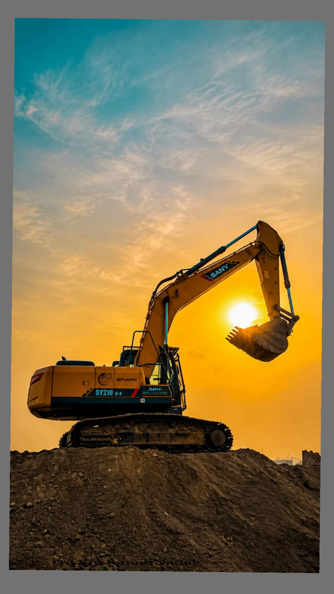 Excavadora sobre un montículo de tierra al atardecer